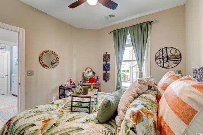 Bedroom with baseboards, visible vents, light colored carpet, and ceiling fan | Image 26
