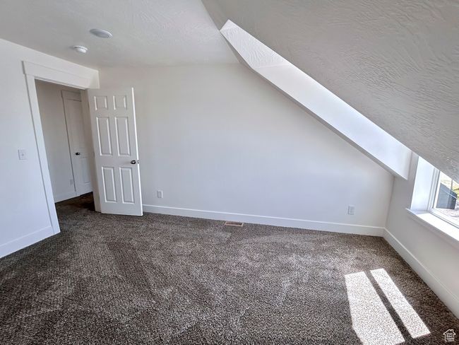 Bonus room with baseboards, dark colored carpet, and vaulted ceiling | Image 27