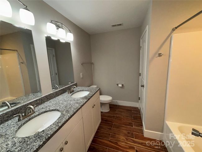Master bath with granite counters and double vanity. Tile floor, combo tub/shower, linen closet. | Image 8
