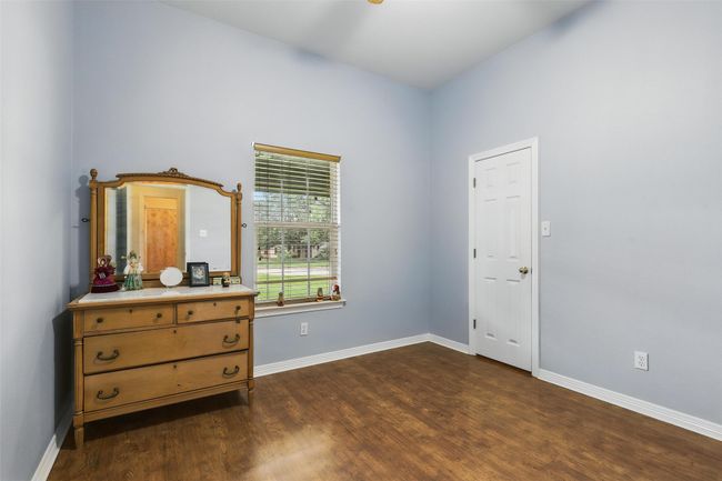Bedroom with dark wood-type flooring and baseboards | Image 26