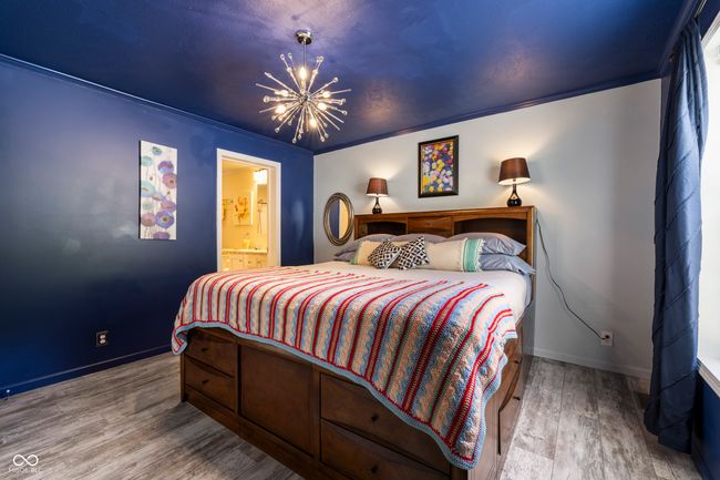 bedroom with a chandelier, wood finished floors, baseboards, and ensuite bath | Image 21
