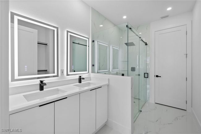 Full bath with marble tiled floors, a marble finish shower, double vanity, and recessed lighting | Image 22