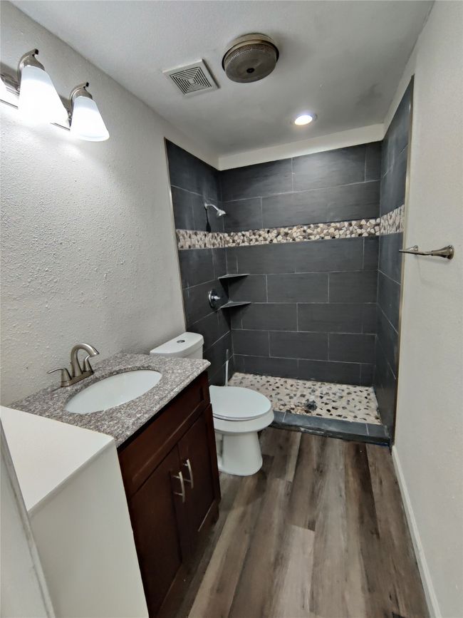 Bathroom with tiled shower, hardwood / wood-style flooring, toilet, and vanity | Image 21