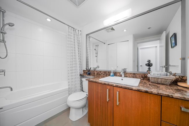 Bathroom with vanity, shower / tub combo, visible vents, and toilet | Image 18