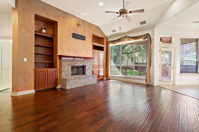 Unfurnished living room with built in shelves, a ceiling fan, visible vents, and a healthy amount of sunlight | Image 5