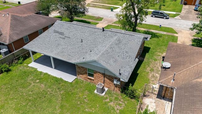An aerial perspective from the rear shows the patio, backyard expanse, and front approach — all on a well-positioned lot. | Image 37
