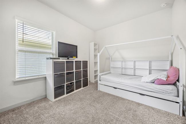 A secondary bedroom, perfect for a child's room or home office, with plush carpeting, a large window, and plenty of space for furniture. | Image 20