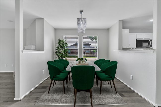 Dining space with wood finished floors, baseboards, and a chandelier | Image 23