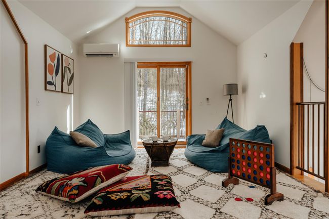 Living room featuring vaulted ceiling and a wall mounted AC | Image 19