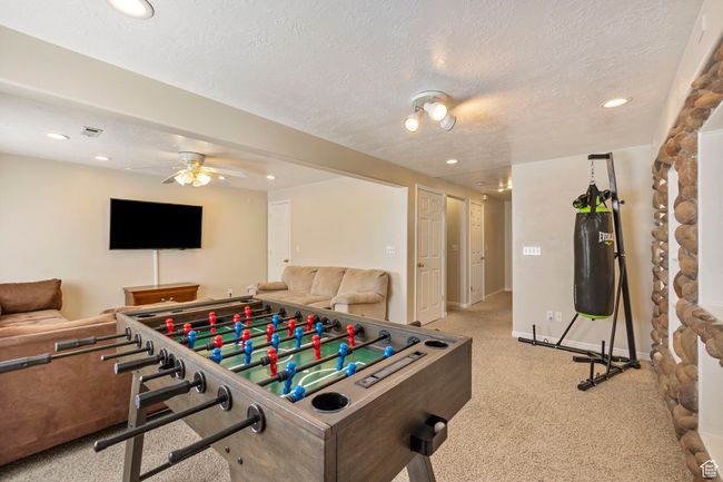Recreation room featuring a ceiling fan, carpet flooring, visible vents, and recessed lighting | Image 29