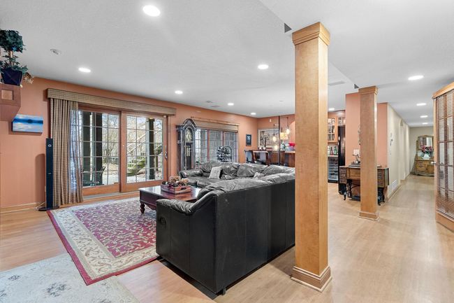 Lower-level recreation room. Bamboo floors. Walk-out slider to hot tub, rod iron fenced area and stairway to upper deck. View of wet bar and hallway to lower-level bedrooms. | Image 41