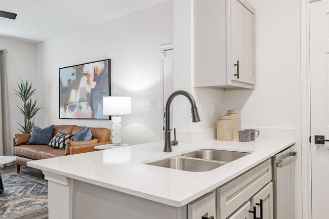 Kitchen with sink, light stone countertops, and stainless steel dishwasher | Image 8