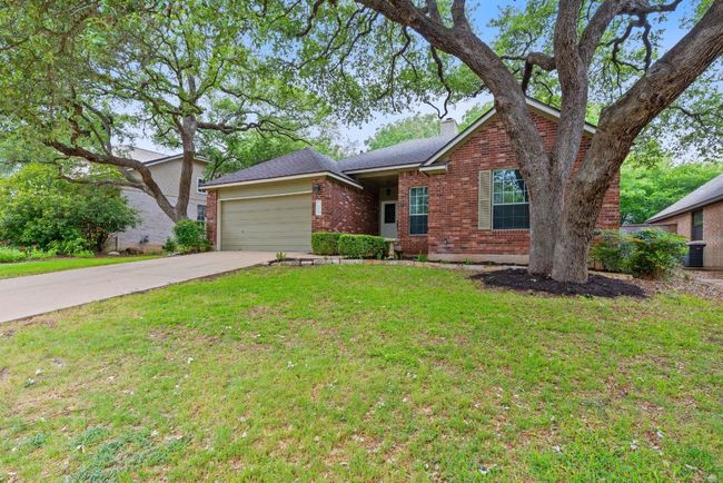 Curb appeal shines with classic red brick masonry, lush landscaping, and towering shade trees. | Image 6