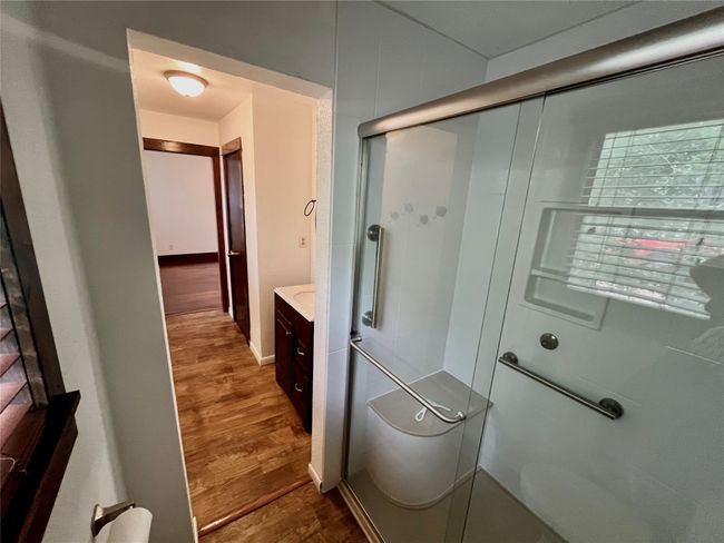 Bathroom with a stall shower, wood floors, and vanity | Image 7