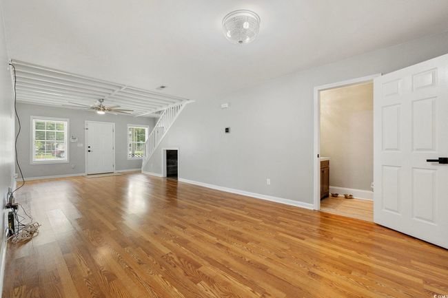 Unfurnished living room with light wood finished floors, baseboards, and ceiling fan | Image 23
