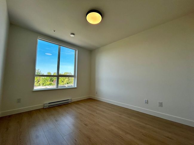 Spare room featuring baseboard heating, wood finished floors, and baseboards | Image 12