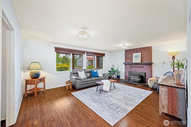 A more formal living room with a gas firplace overlooks the front of the home and approach. | Image 13