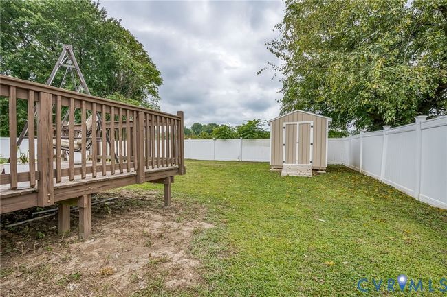 Fenced backyard featuring a storage shed and a wooden deck | Image 23