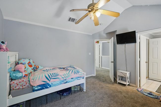 Bedroom with vaulted ceiling, light carpet, ornamental molding, and ceiling fan | Image 30