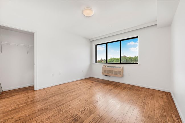 Unfurnished bedroom with wood finished floors, a wall mounted air conditioner, and a closet | Image 20
