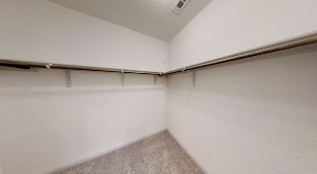 Spacious closet with vaulted ceiling and carpet | Image 12
