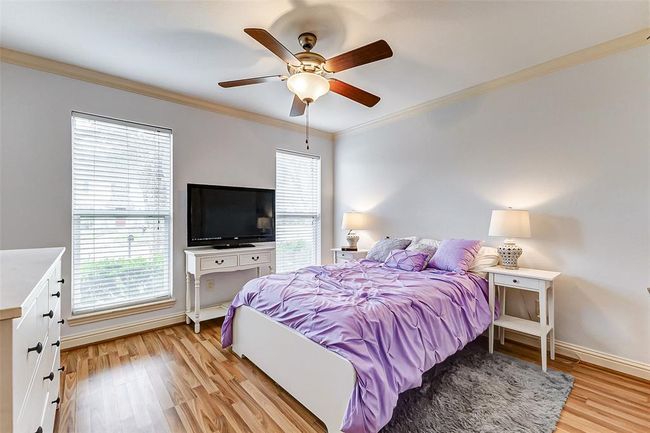 Bright and airy, this secondary bedroom features a generous layout, large windows, and a ceiling fan for year-round comfort. A soft neutral palette enhances the sense of space, making it a welcoming retreat. | Image 33