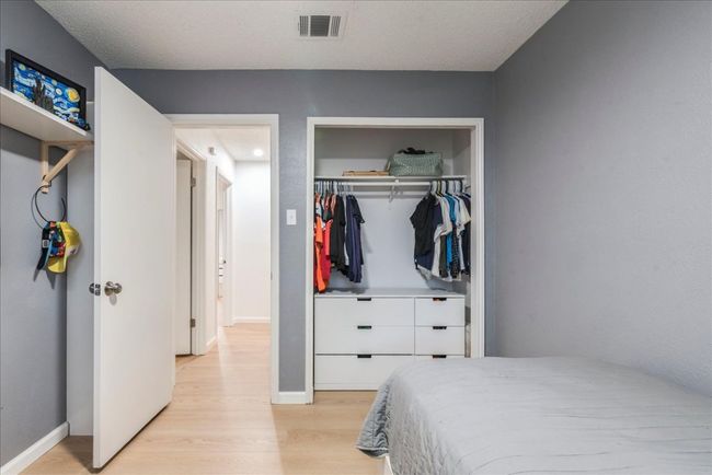 Bedroom with baseboards, visible vents, a closet, and light wood-style floors | Image 17