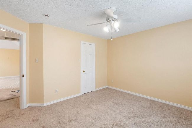 Empty room with ceiling fan, baseboards, a textured ceiling, and light colored carpet | Image 20