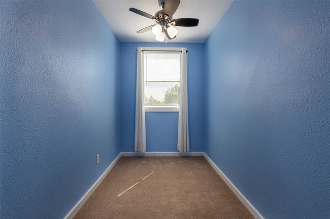 Spare room featuring a textured wall, ceiling fan, carpet, and baseboards | Image 25