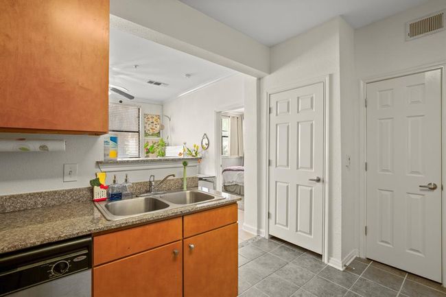 Kitchen featuring dishwasher, tile patterned floors, a ceiling fan, and brown cabinets | Image 5