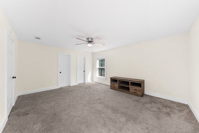 Carpeted empty room featuring ceiling fan and baseboards | Image 16