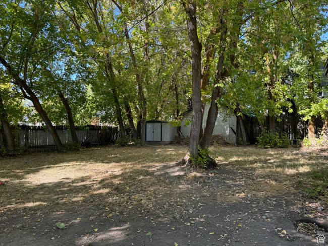 View of yard featuring fence, an outbuilding, and a storage shed | Image 33