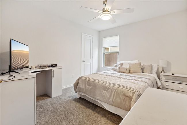 Bedroom with light colored carpet and a ceiling fan | Image 8