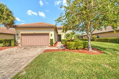 Mediterranean / spanish-style home featuring a garage and a front lawn | Image 1