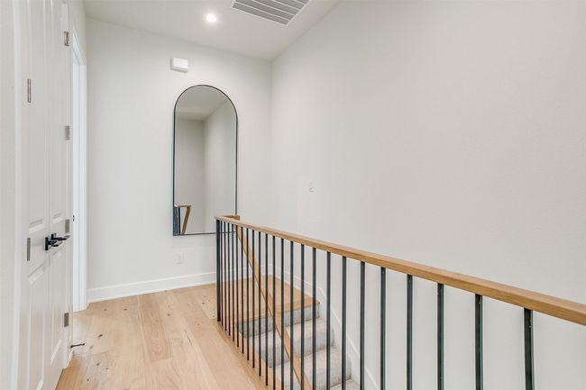Hallway featuring light wood-style flooring, recessed lighting, baseboards, visible vents, and an upstairs landing | Image 17
