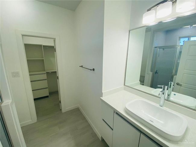 Bathroom featuring a shower stall, vanity, and a spacious closet | Image 11
