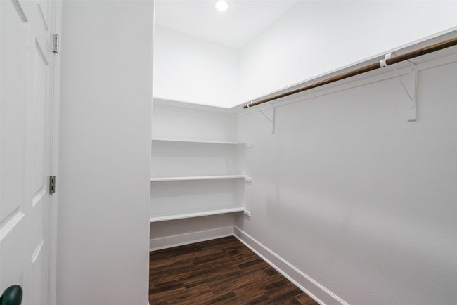 Walk in closet featuring dark wood-style floors | Image 19