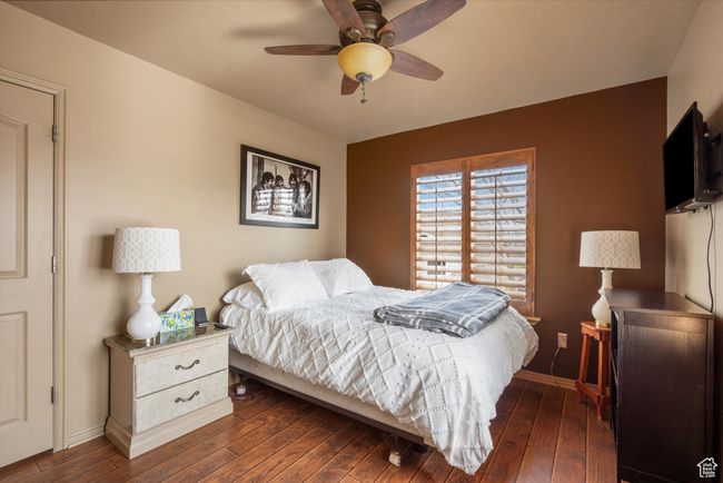 Bedroom with dark wood-type flooring, baseboards, and ceiling fan | Image 20