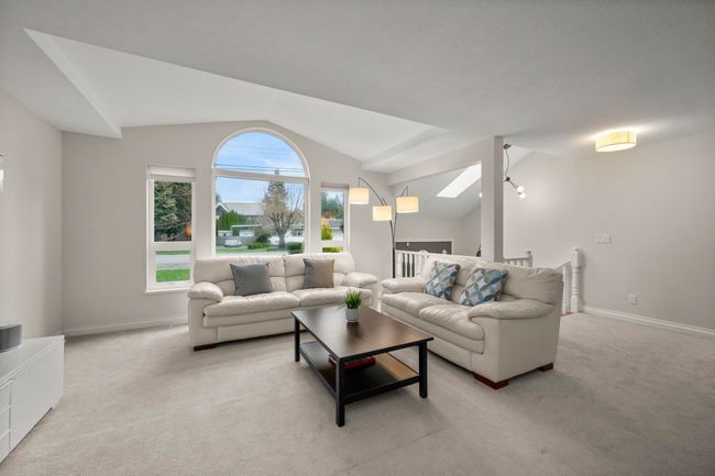 Living area with light carpet, baseboards, and lofted ceiling | Image 6