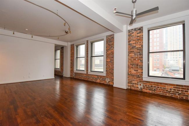Bright and inviting living area filled with natural light, featuring large windows that showcase stunning Downtown Houston views. A perfect space to relax or entertain while enjoying the city skyline. | Image 10