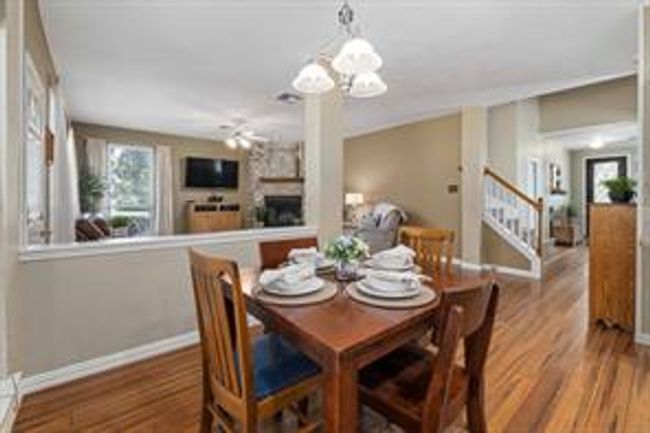Dining area featuring stairway, baseboards, a large fireplace, and wood finished floors | Image 21