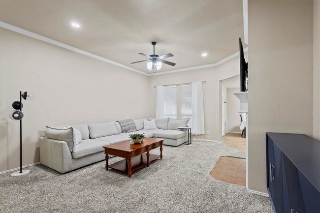 Living area featuring ceiling fan, baseboards, and crown molding | Image 8