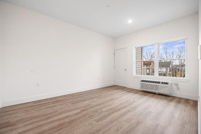 Spare room featuring a wall unit AC, wood finished floors, baseboards, and recessed lighting | Image 39