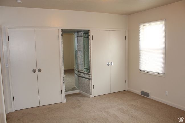 Unfurnished bedroom featuring light colored carpet and baseboards | Image 8