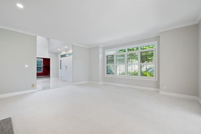 Unfurnished living room featuring crown molding, recessed lighting, light colored carpet, and baseboards | Image 8