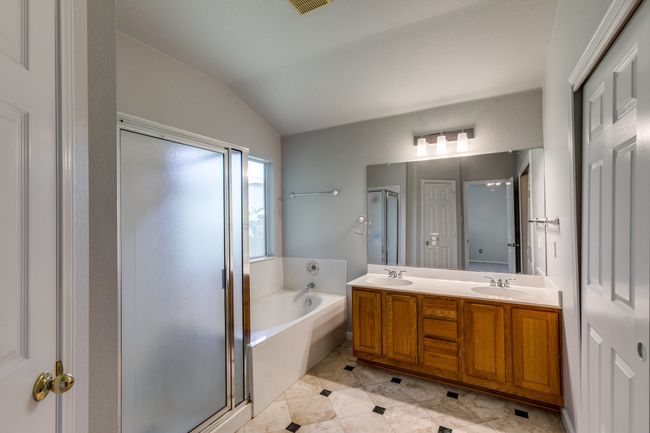 Master Full bathroom with lofted ceiling, a stall shower, a bath, double vanity, and tile patterned flooring | Image 30