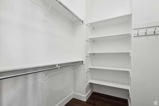 Spacious closet with dark wood-type flooring | Image 19