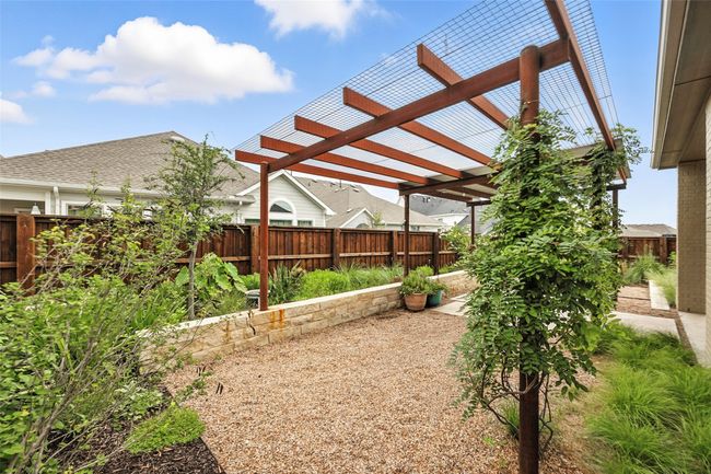 Fenced backyard with a pergola | Image 35