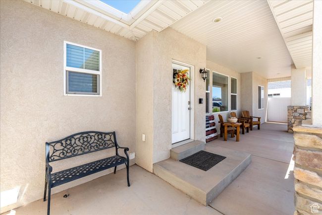 Doorway to property featuring stucco siding and a porch | Image 5