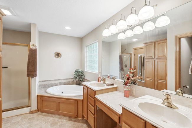 Bathroom featuring a stall shower, vanity, a jetted tub, and recessed lighting | Image 12